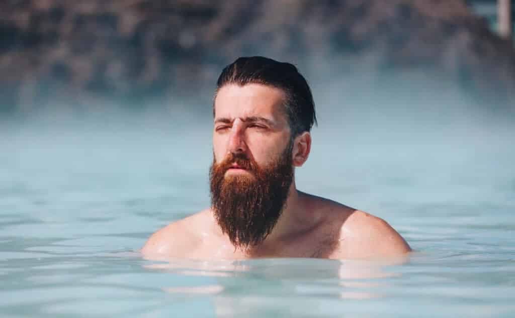גבר עם זקן מלא וארוך שוחה באגם